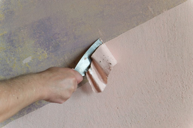 tẩy sơn tường trên nền nhà bằng dụng cụ cạo sơn