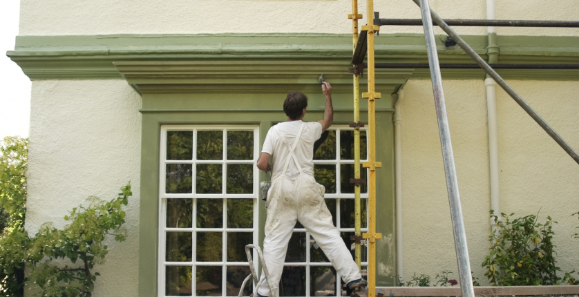Painter decorating a house exterior.