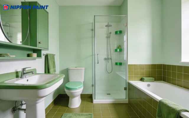 Phòng tắm hiện đại với tường xanh nhạt, thiết bị vệ sinh tinh giản và bố cục gọn gàng