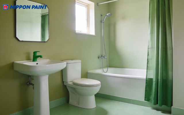 Gạch ốp tường màu xanh mint bóng nhẹ, phản chiếu ánh sáng, làm nổi bật sự sạch sẽ của phòng tắm