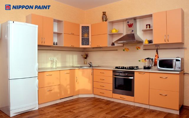 Phòng bếp được sơn tông cam từ tường tới giá kệ