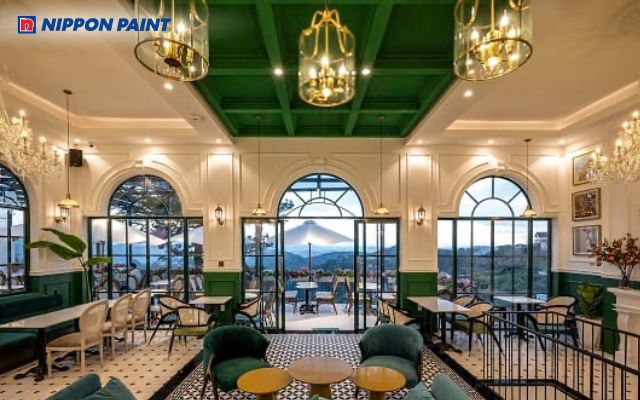 Quán cà phê sang trọng với màu sơn trắng be thanh lịch, kết hợp ánh đèn vàng ấm cúng