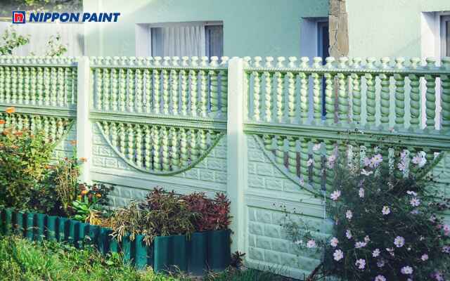 Hàng rào bê tông sơn màu xanh lá tươi mát, hài hòa với sân vườn và cây cối