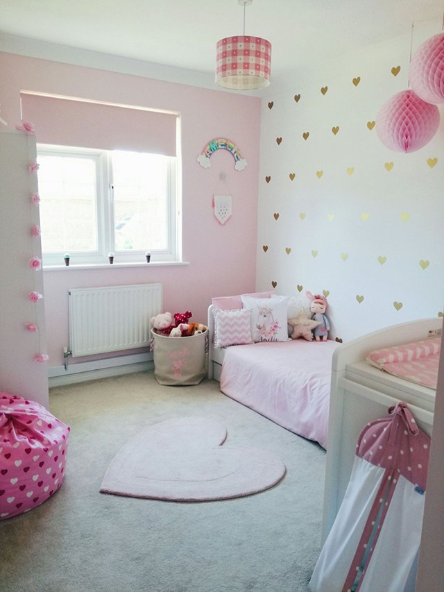 Màu hồng phấn kết hợp với màu trắng và màu hồng đậm của đèn trang trí giúp căn phòng của bé gái trở nên ngọt ngào.
