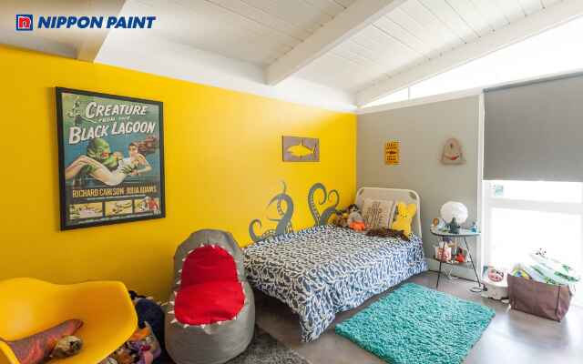 Tường màu vàng kết hợp nội thất sáng màu tạo phòng vui tươi và dễ chịu cho bé trai