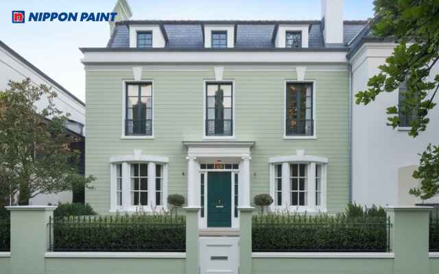 Mẫu 1: Nhà phố hiện đại sơn màu xanh lá cây kết hợp cửa kính sáng và ban công trắng tinh tế