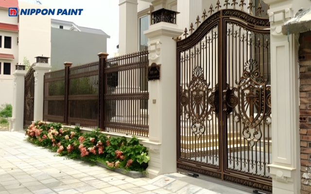 Hàng rào vàng nâu đậm cùng hoa văn uốn lượn tinh tế tạo điểm nhấn ấn tượng cho ngôi nhà