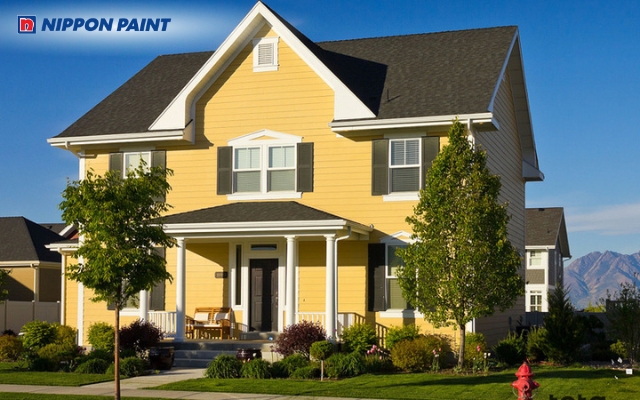 Mặt tiền nhà sơn vàng nâu nổi bật dưới ánh sáng tự nhiên, mang lại sự tinh tế