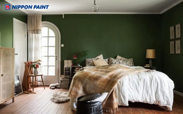 Mảng tường xanh rêu đậm phía đầu giường tạo điểm nhấn tĩnh lặng cho căn phòng