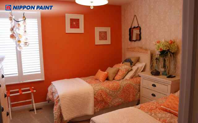 Không gian phòng ngủ nổi bật với tông cam đậm, đem lại sự sinh động và tươi mới