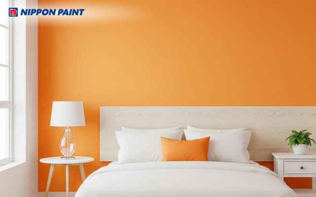 Phòng ngủ tone cam nhạt nổi bật với tranh trang trí và ánh sáng tự nhiên dễ chịu