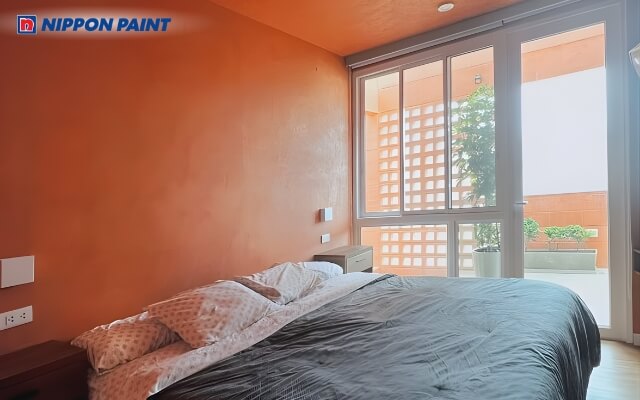 Phòng ngủ màu cam, và ga giường có màu đồng bộ, ấm cúng