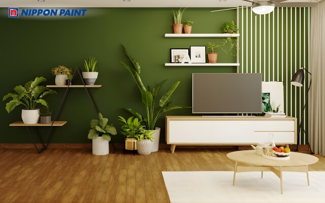 Phòng khách tường xanh lá, cây xanh và nội thất trang trí hài hòa